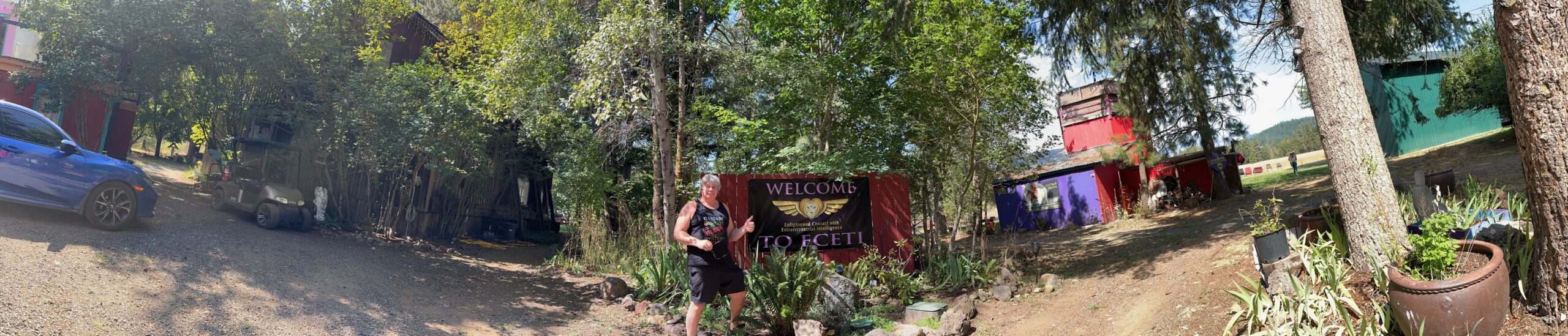 Matthew Heines giving a thumbs up in front of the Welcome to ECETI Ranch banner at the famous high strangeness location