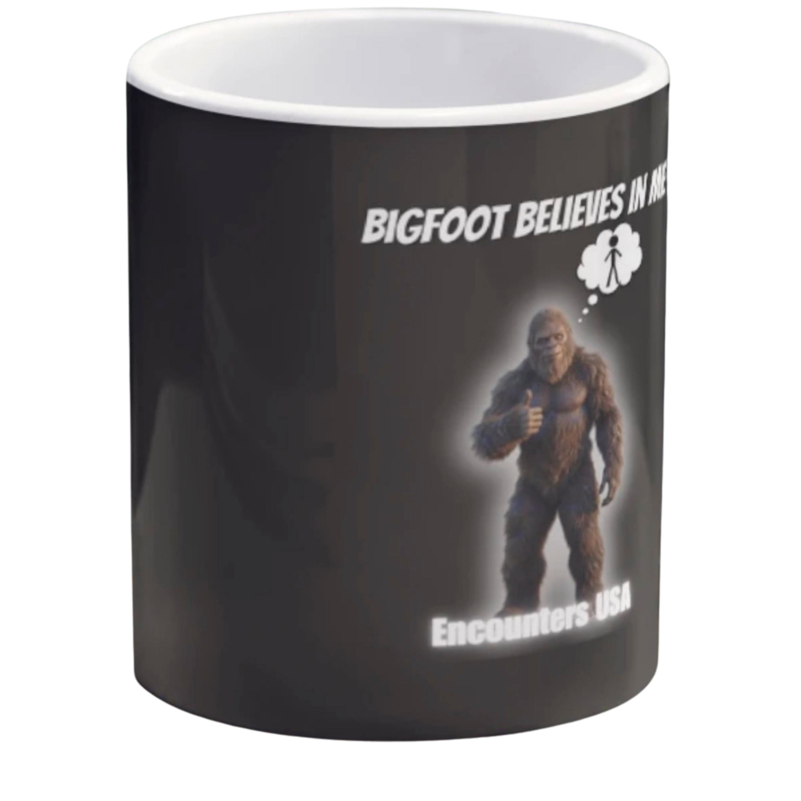 Black ceramic coffee mug with funny Bigfoot design saying "BIGFOOT BELIEVES IN ME" and a thumbs-up Sasquatch with thought bubble. Encounters USA merch.