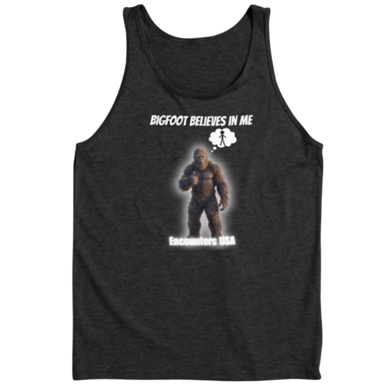 Dark gray tank top with motivational Bigfoot design "BIGFOOT BELIEVES IN ME" showing Sasquatch giving thumbs up. Funny cryptid summer apparel.